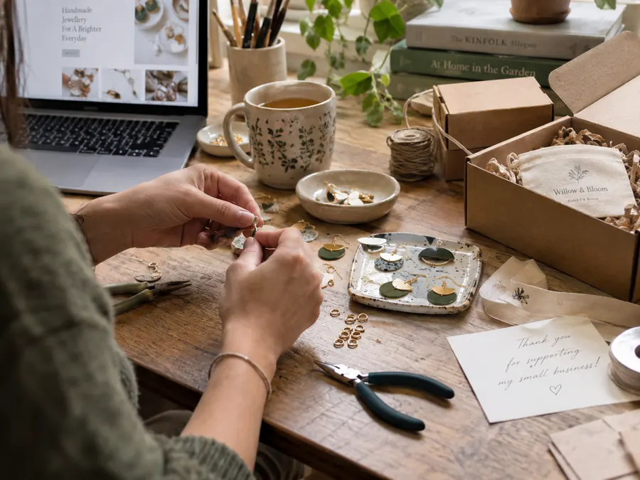 Making jewellery at a workbench with small gift boxes